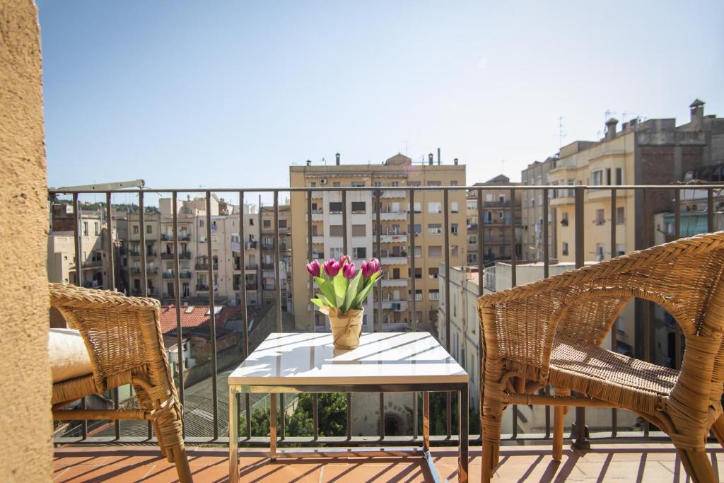 a table with a vase of flowers on a balcony at 41COB1019- Charming rustic apartment in Barcelona