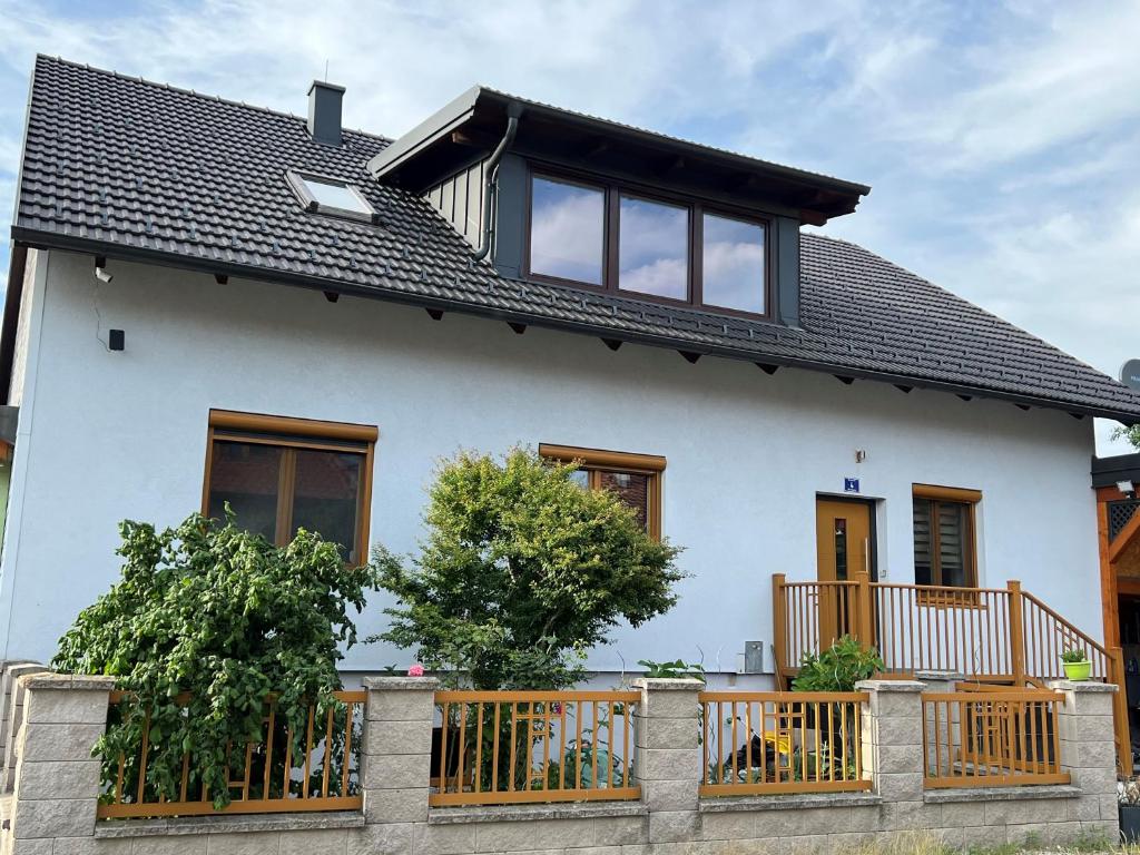 uma casa branca com uma cerca de madeira em frente em Ferienzimmer zwischen Wien und Tulln em Tulln