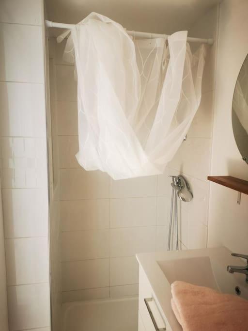 a bathroom with a shower with a white shower curtain at Appartement avec terrasse in Saint-Martin-de-Brômes