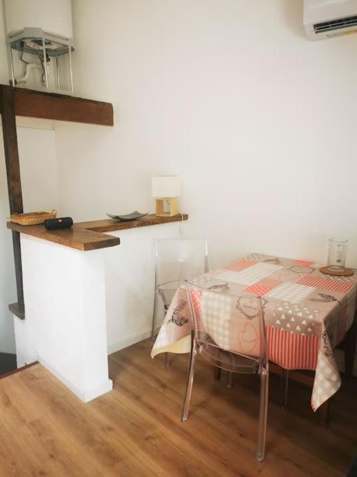 a table and a chair in a room with a counter at Appartement avec terrasse in Saint-Martin-de-Brômes