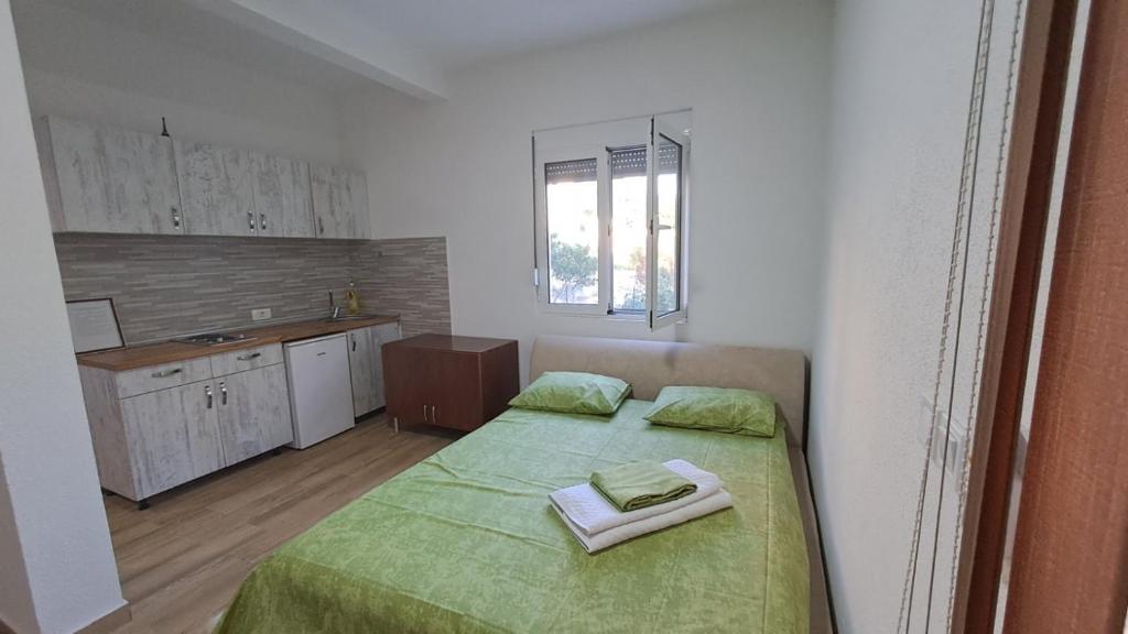 a small bedroom with two beds and a kitchen at Spasic Apartments Sutomore in Sutomore