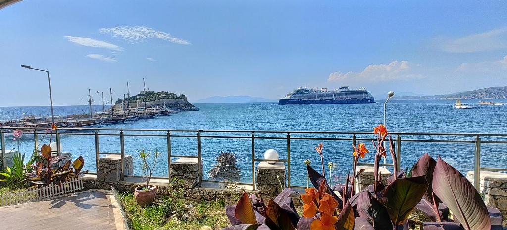 a cruise ship in the water next to a fence at Waterfront Glass Flat in Kuşadası