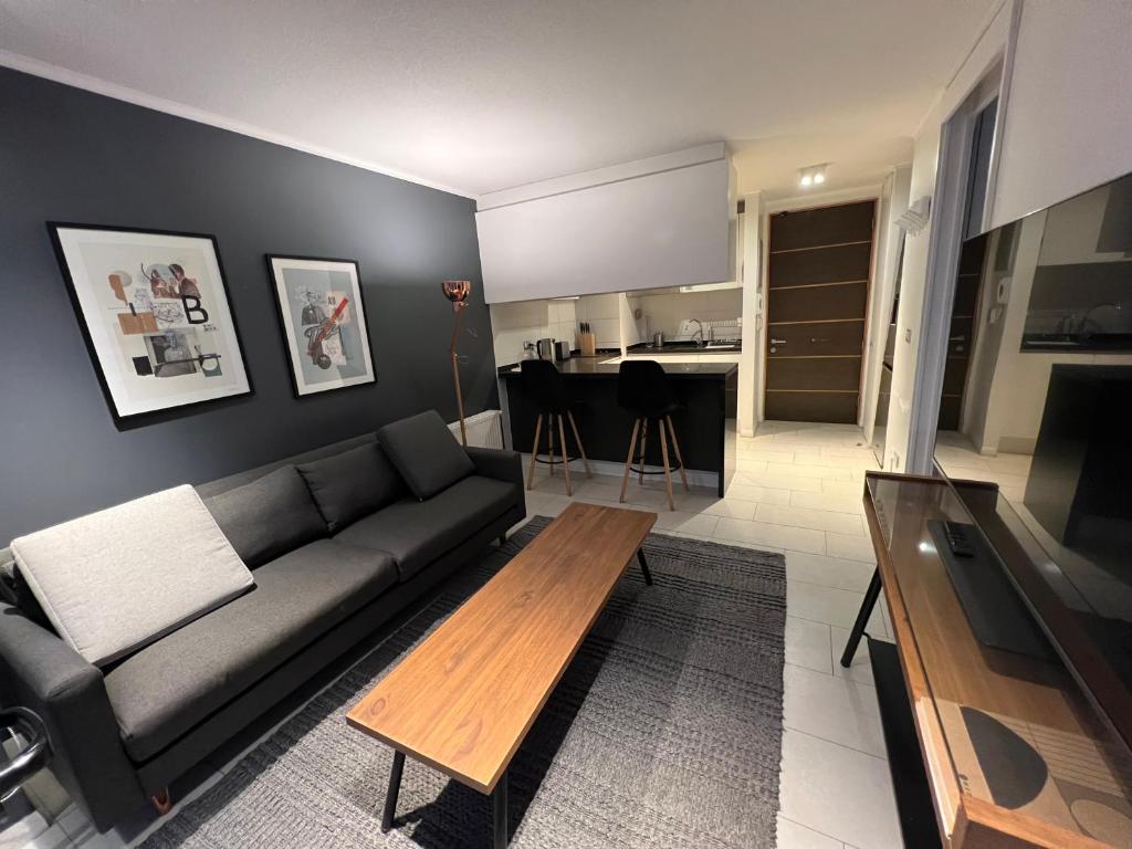 a living room with a couch and a table at Oceana Suites Capital in Santiago