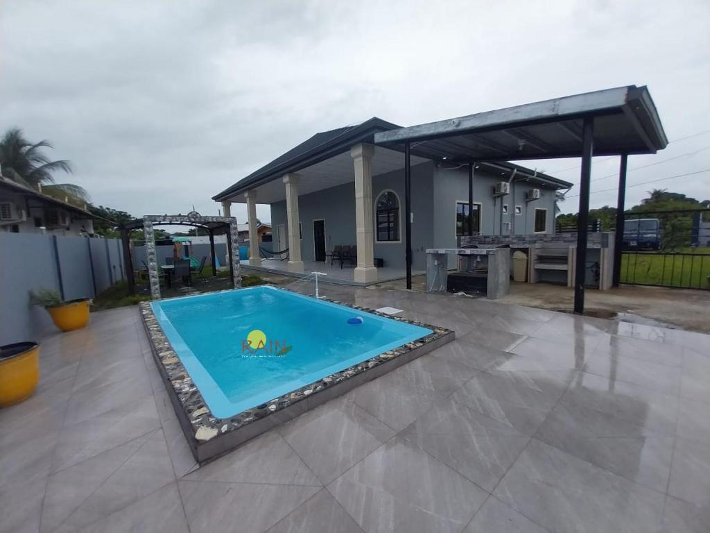 einen Pool in der Mitte einer Terrasse in der Unterkunft kdk villa in Buccoo