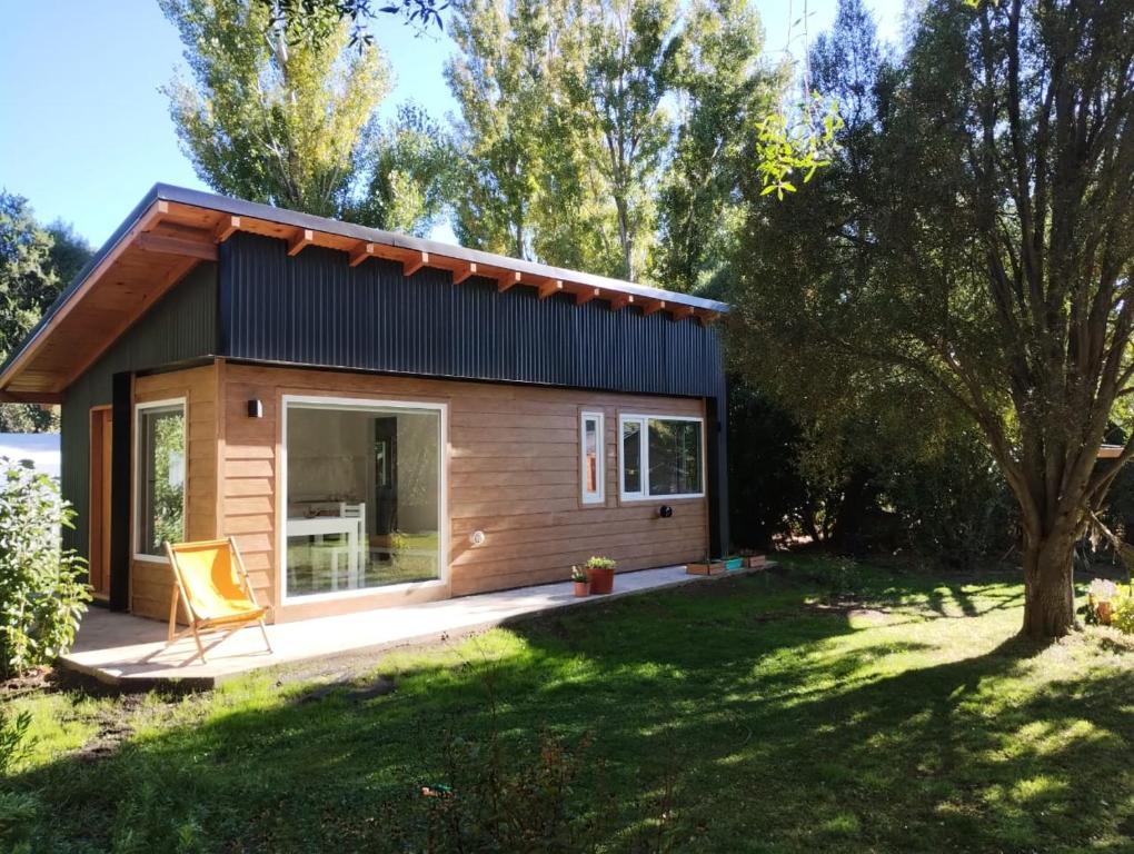 una casa pequeña con porche y patio en Casa nueva en Bariloche a orillas del Nahuel Huapi en San Carlos de Bariloche