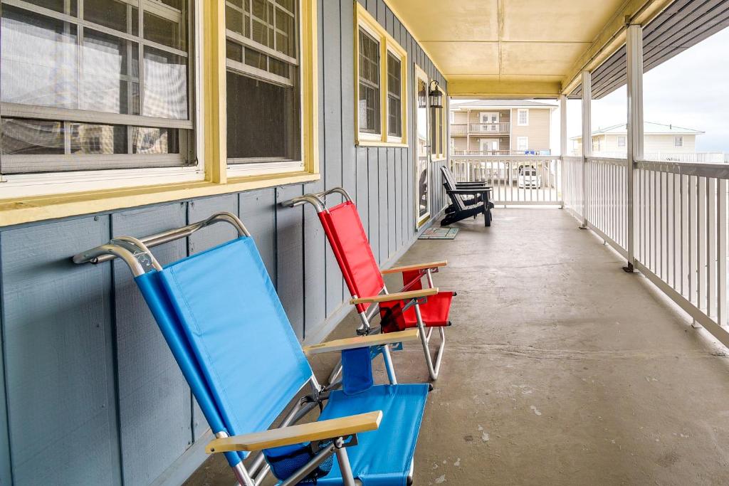 3 Stühle auf einer Veranda eines Hauses in der Unterkunft Steps to Ocean North Myrtle Beach Condo with Porch! in Myrtle Beach
