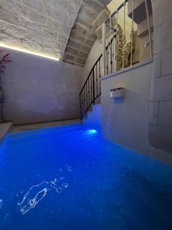 Cette chambre dispose d'un sol bleu et d'une piscine. dans l'établissement Handy Specus, à Brindisi