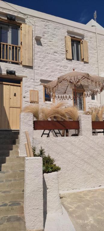 un bâtiment avec deux bancs et un parasol dans l'établissement ClockWise Earthy Vibe House in Apano Chora, à Áno Sýros