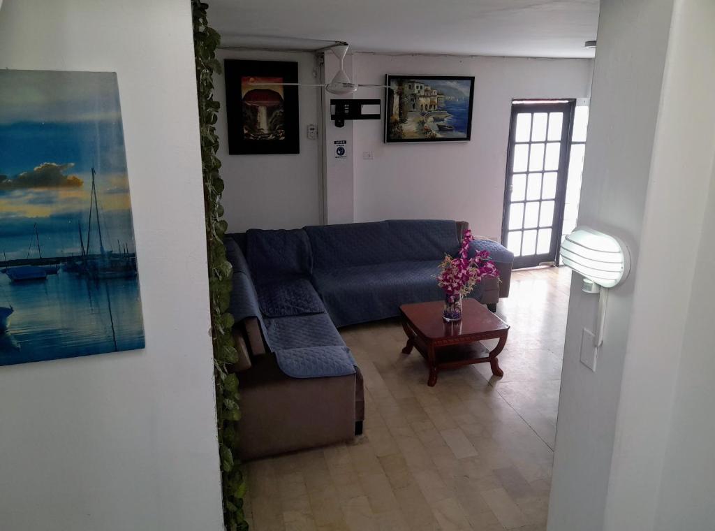 a living room with a blue couch and a table at La Villa de Norma in Guayaquil