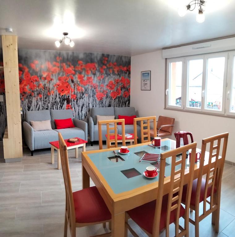 une salle à manger avec une table et des chaises dans l'établissement Les Coquelicots, à Cormaranche-en-Bugey