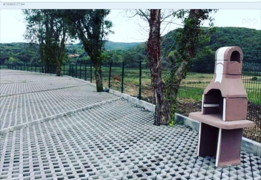 un banco sentado en una acera junto a una valla en Yılmaz camping, 