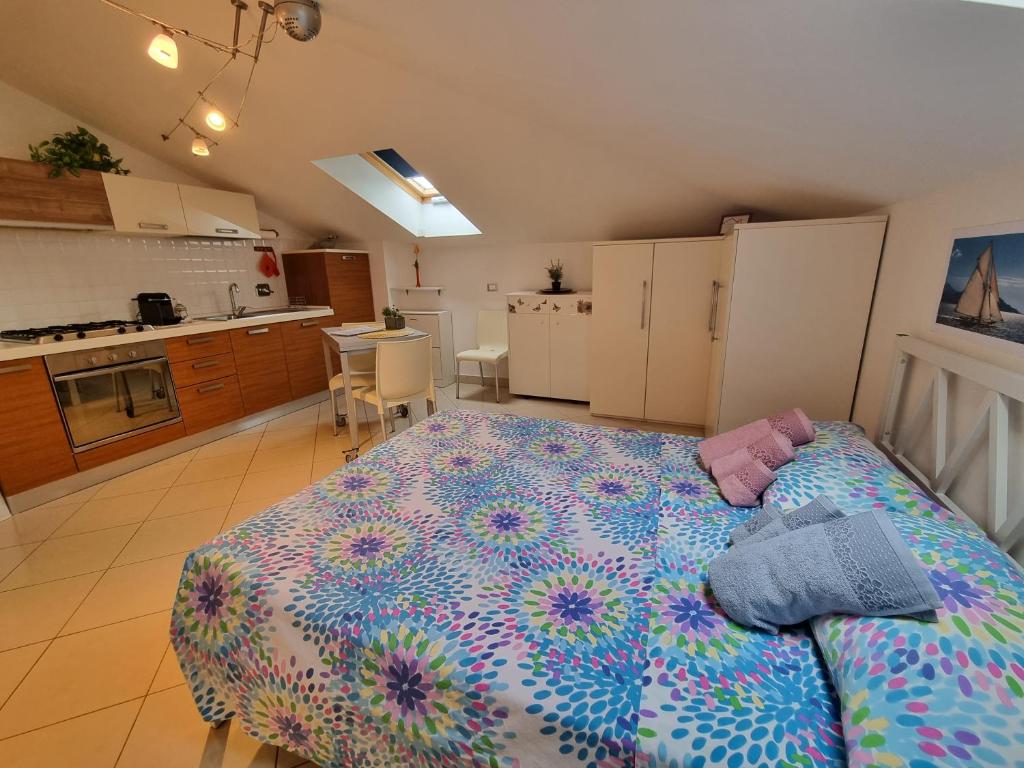 a bedroom with a large bed and a kitchen at La Mansarda di Noi2 in Spotorno