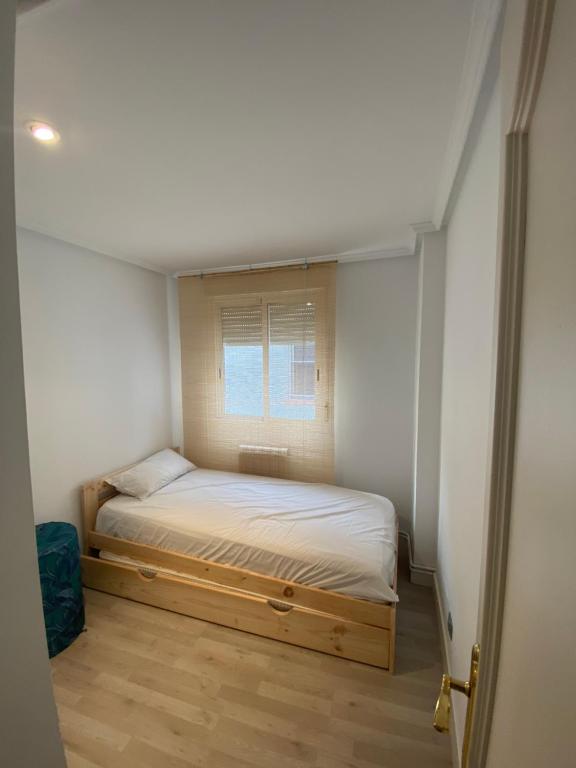 une petite chambre avec un lit et une fenêtre dans l'établissement Príncipe habitaciones, à Madrid