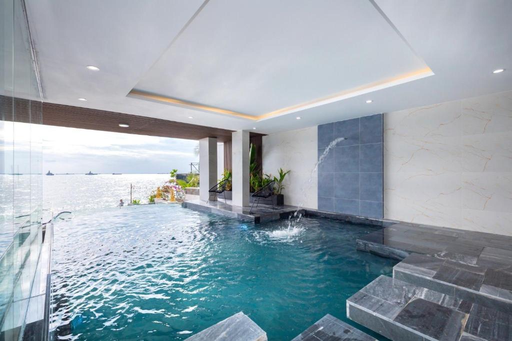 una piscina en medio de una casa con agua en The Palm Villa 24 Luxury ( 6 Bedroom , Karaoke, Bi-da ) en Vung Tau