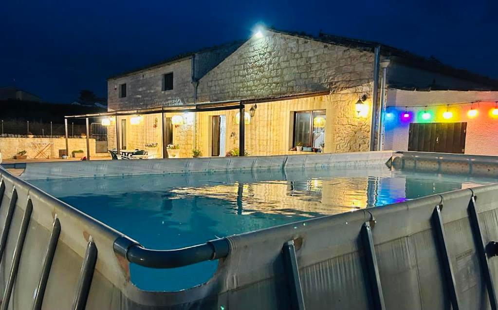 a swimming pool in front of a building at night at Il Casale di Luisa in Modica