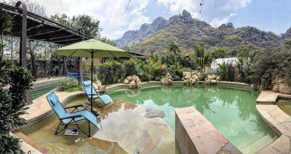Amatlán的住宿－Casa IxeYolo，游泳池旁的椅子和遮阳伞