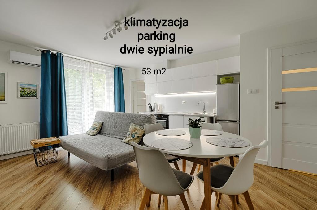 ein Wohnzimmer mit einem Tisch und einem Sofa in der Unterkunft Apartamenty MM - Chmielna in Zielona Góra