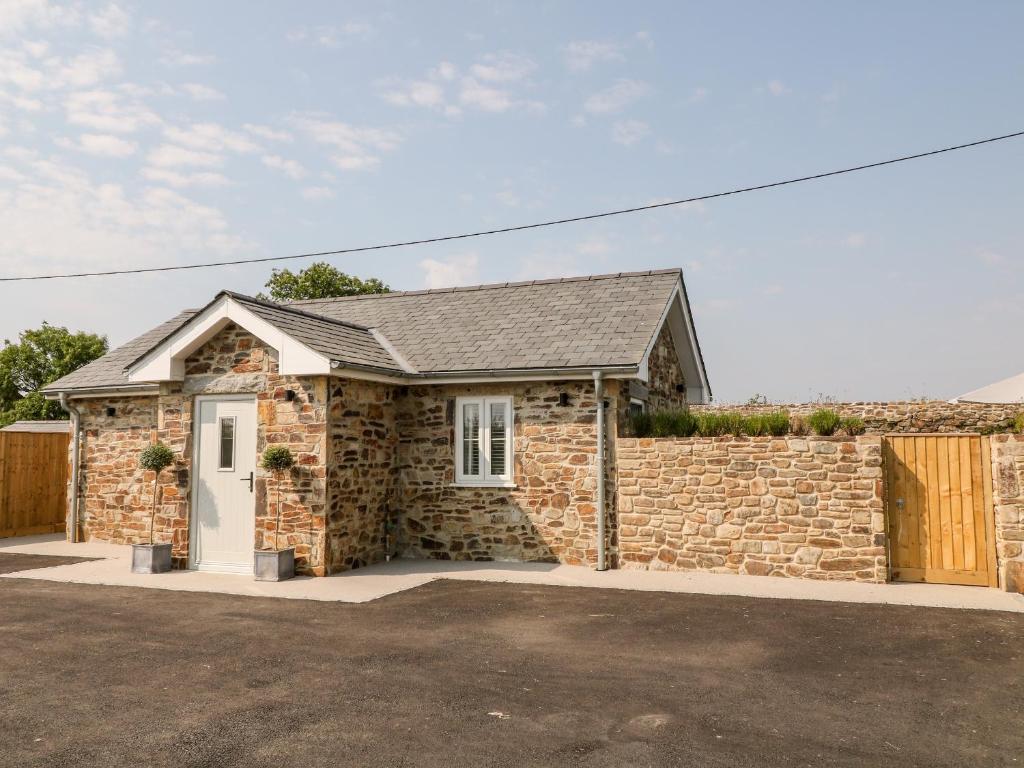 a stone house with a brick wall at Pear Tree Cottage in Saltash