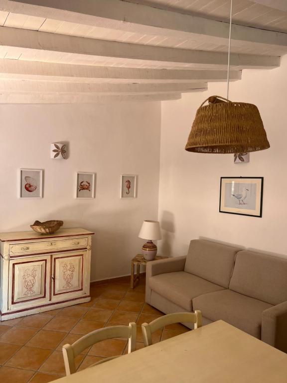 un soggiorno con divano e tavolo di Appartamento il Paguro a Cala Francese a La Maddalena