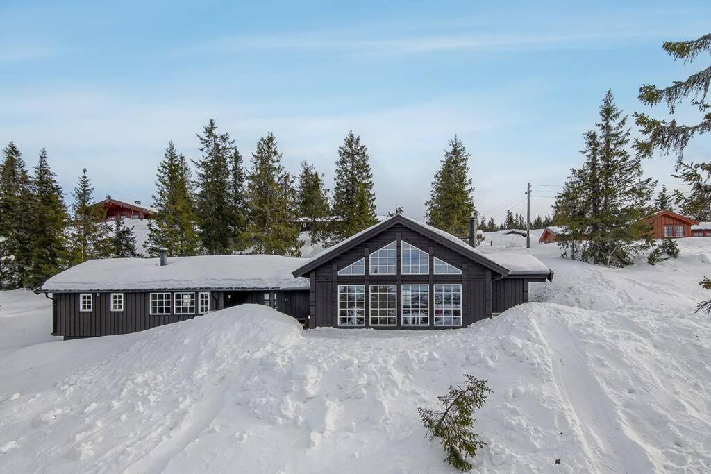a house with a pile of snow in front of it at Holiday home in beautiful Sjusjøen, near Lillehammer in Ringsaker