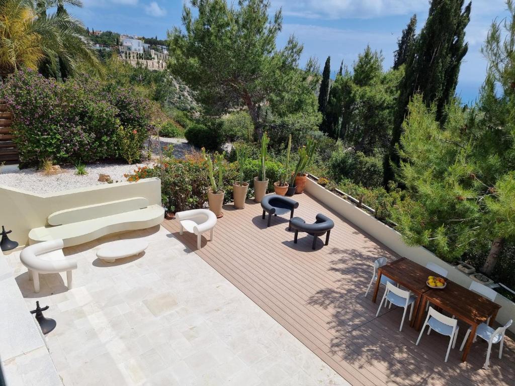 a patio with a couch and chairs and tables at EXQUISITE GOLF VILLA with Sea, 8Tee, Green Views, in Aphrodite Hills Golf Resort in Kouklia