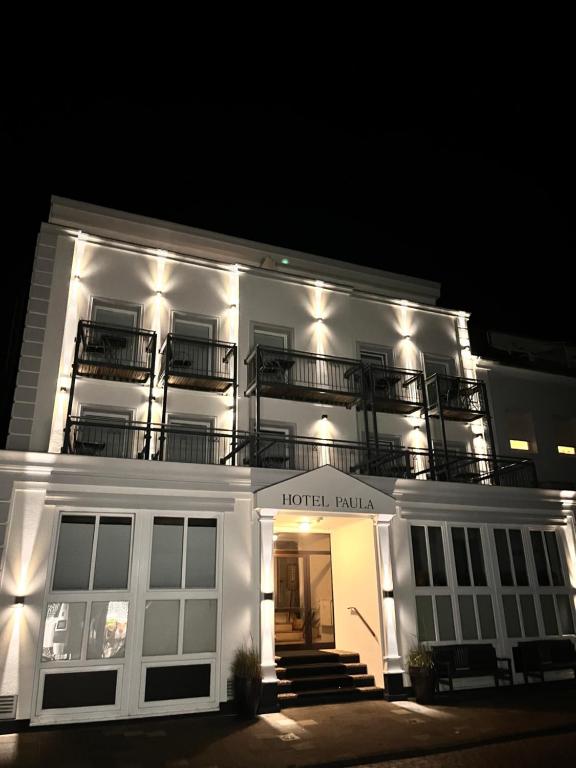 ein weißes Gebäude mit Balkon darüber in der Unterkunft Hotel Paula Norderney in Norderney