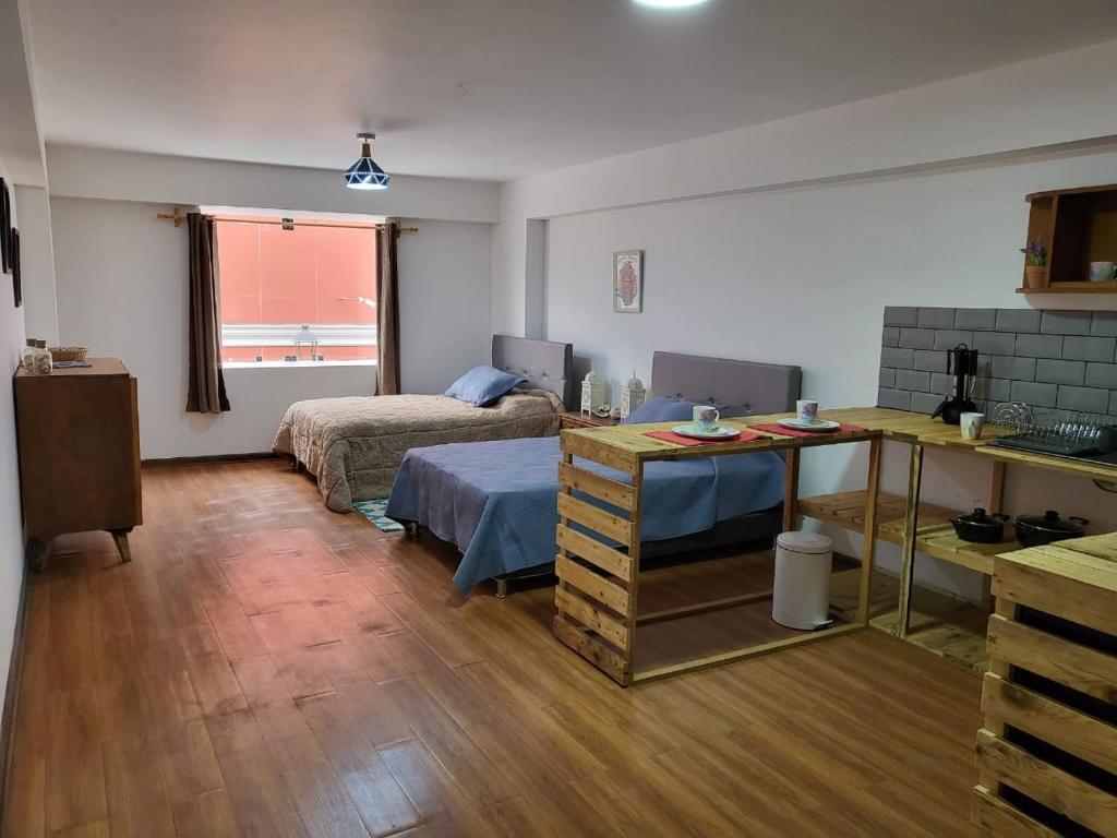 Habitación con 2 camas y mesa. en Espaciosos y lindos mini apartamentos, en Lima