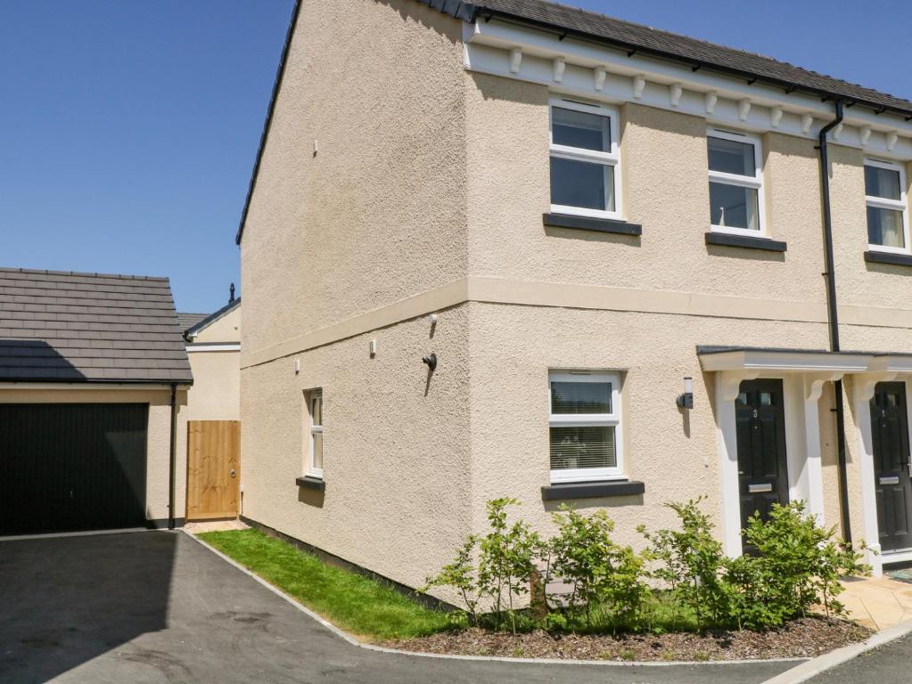 a brick house with a driveway and a garage at Meadow Bay in Bideford