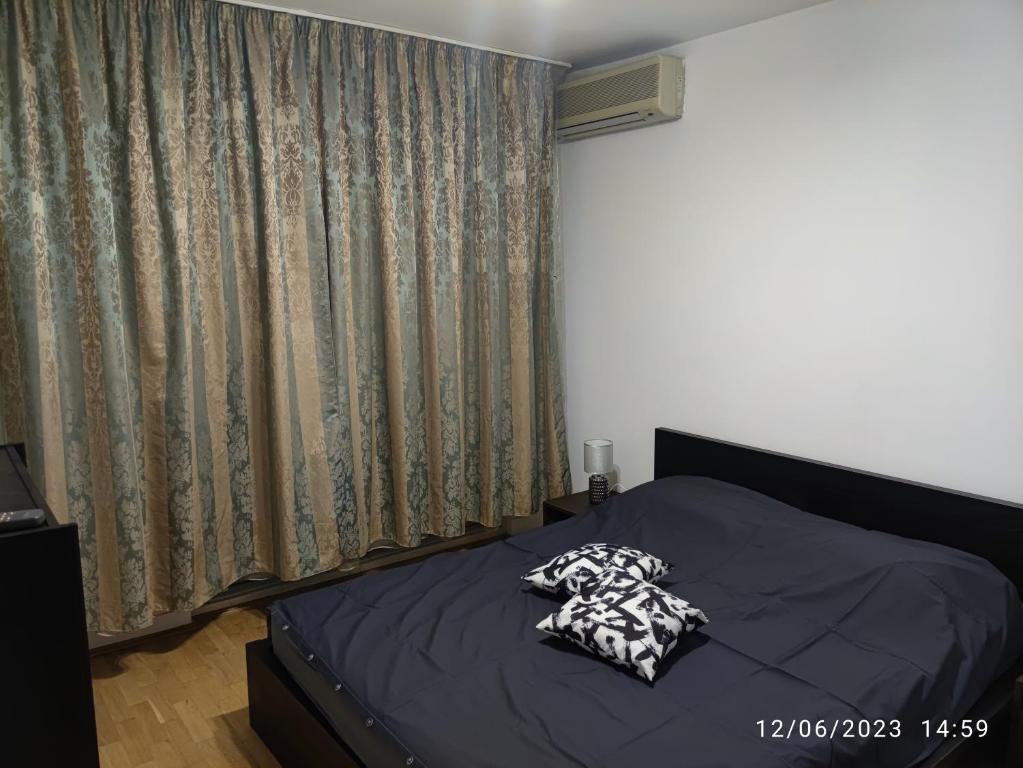 ein Bett mit zwei Kissen darauf in einem Schlafzimmer in der Unterkunft Fabian central apartment in Bukarest