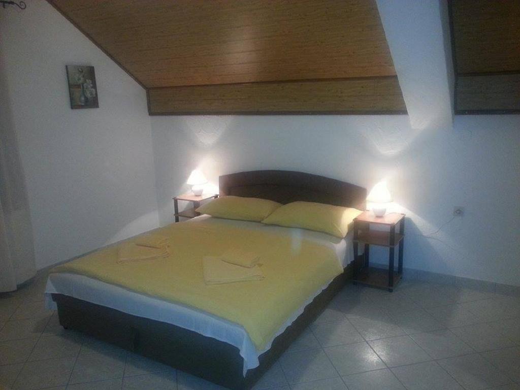a bedroom with a bed with two lamps on it at Guesthouse Magdalena in Rakovica