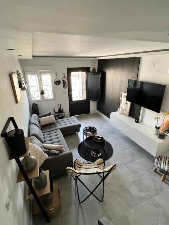 ein Wohnzimmer mit einem Sofa und einem Tisch in der Unterkunft Prachtig gemoderniseerde woning op 250 meter van het strand in Santa Pola