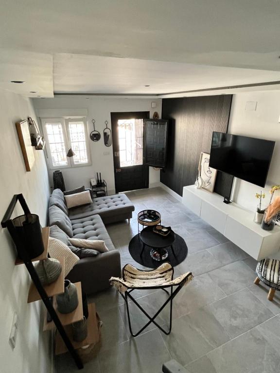 a living room with a couch and a table at Prachtig gemoderniseerde woning op 250 meter van het strand in Santa Pola