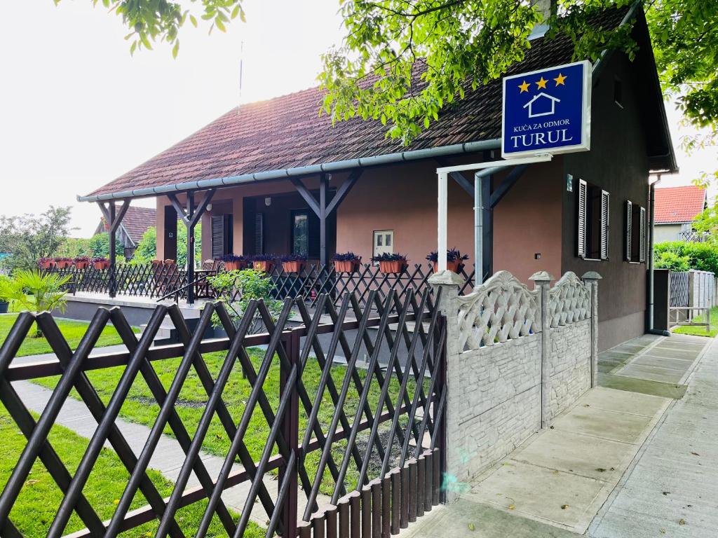 a fence in front of a building with a sign at Turul -Kuća za odmor- in Korođ