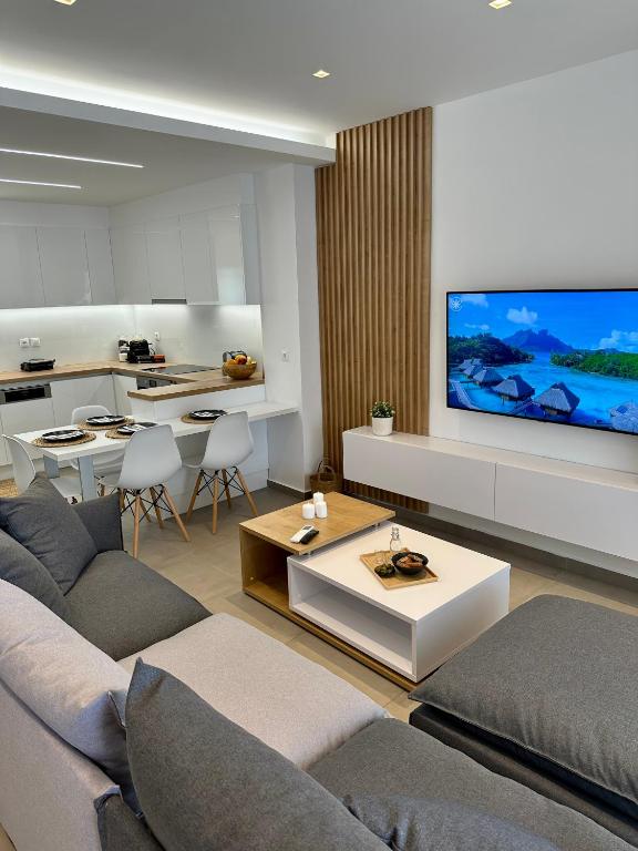 a living room with a couch and a flat screen tv at Rodanthi 4 Seasons Unique House in Tympáki