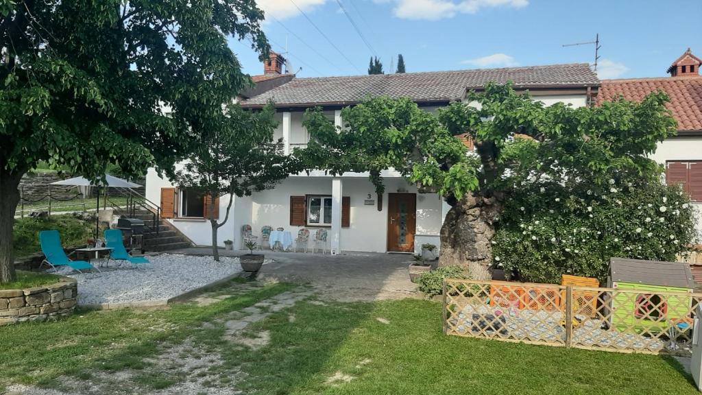 uma casa branca com uma árvore no quintal em Country House Gazon em Šmarje