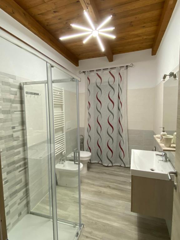 een badkamer met een glazen douche en een toilet bij B&B al Vicoletto in Bellante