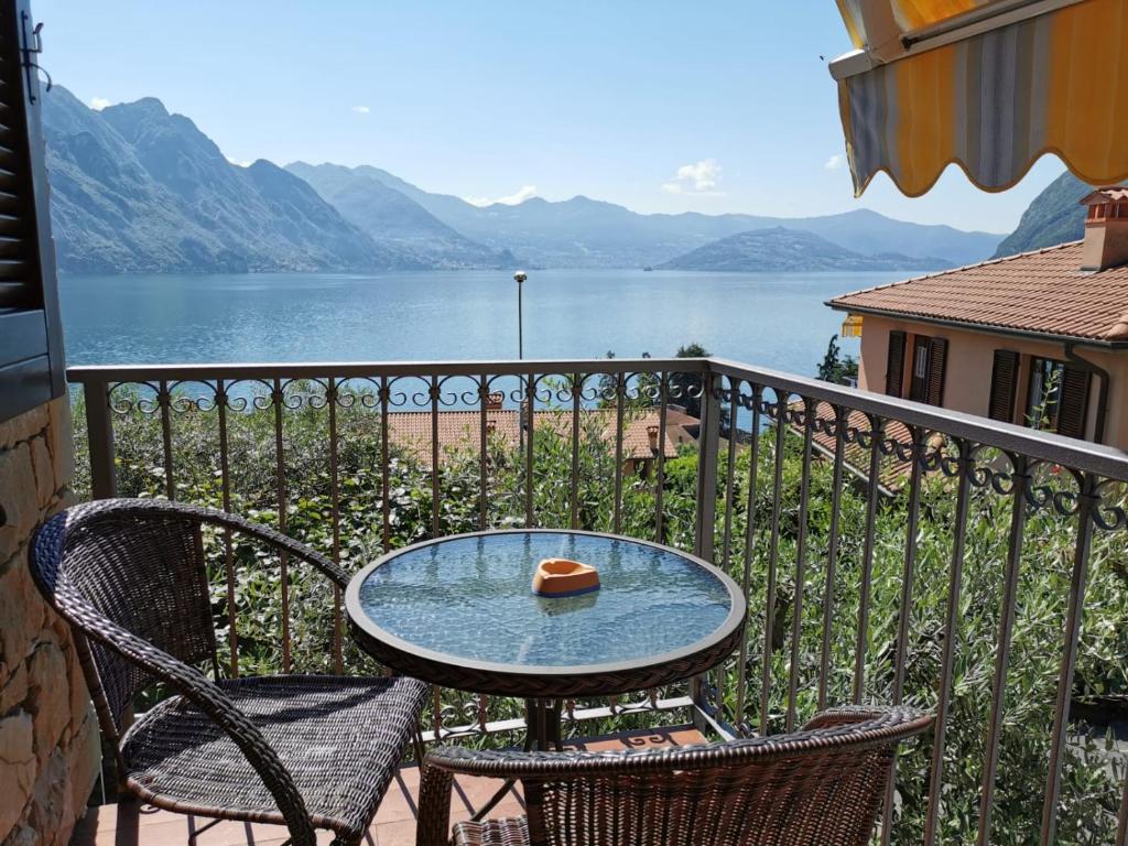 a table and chairs on a balcony with a view of the water at Appartamento Gelsomino in Riva di Solto