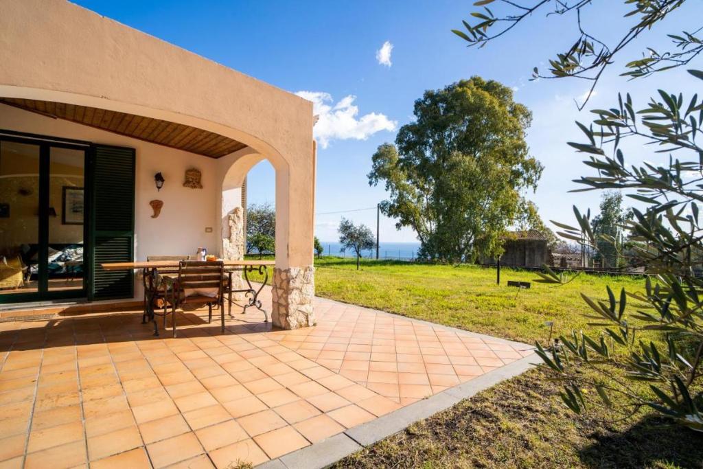 un patio con mesa y césped en Villa Etna Pippo, en Piedimonte Etneo