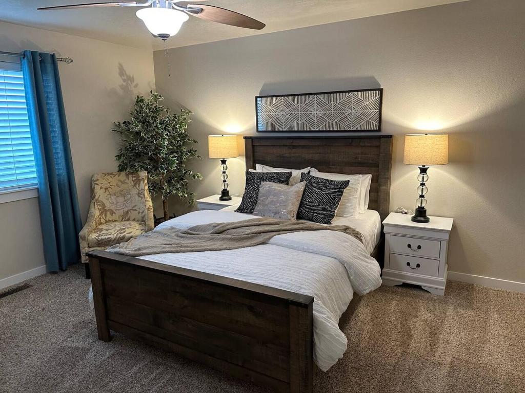 a bedroom with a bed with two lamps and a chair at 2 Story Meridian Home in Meridian