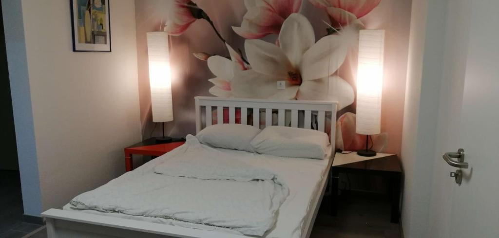 - une chambre avec un lit orné de fleurs sur le mur dans l'établissement Vacational apartment, à Bottrop