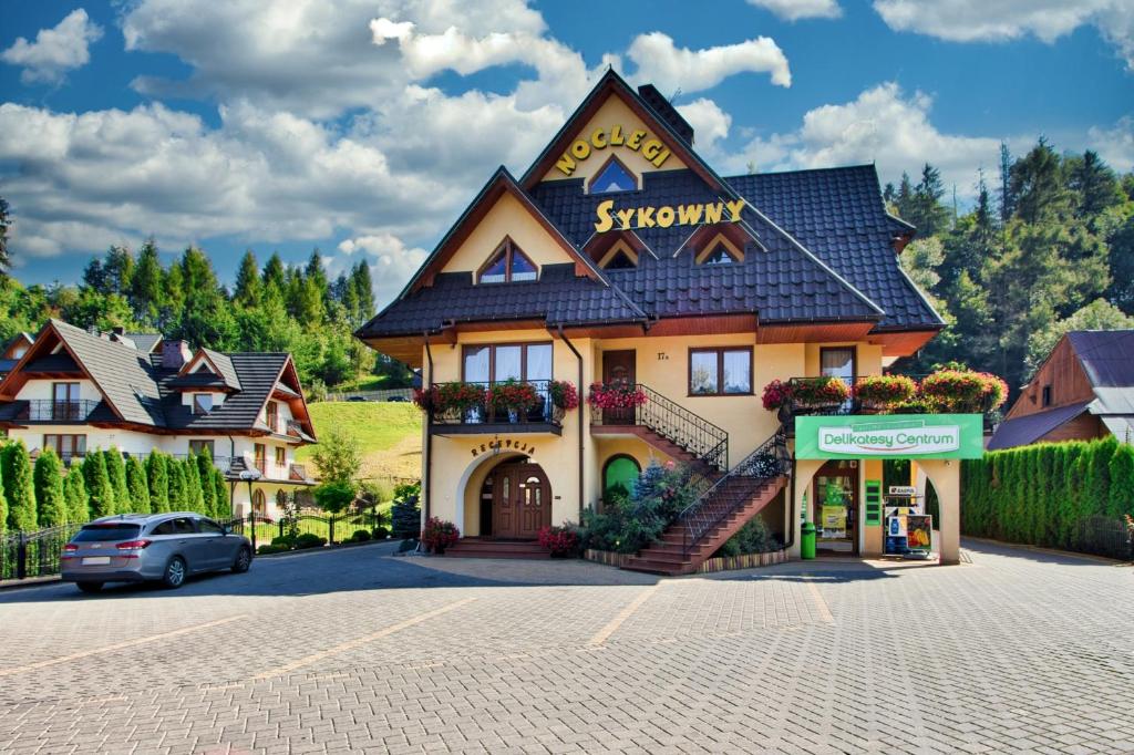 a building with a sign on the front of it at Sykowny Biały Dunajec in Zakopane