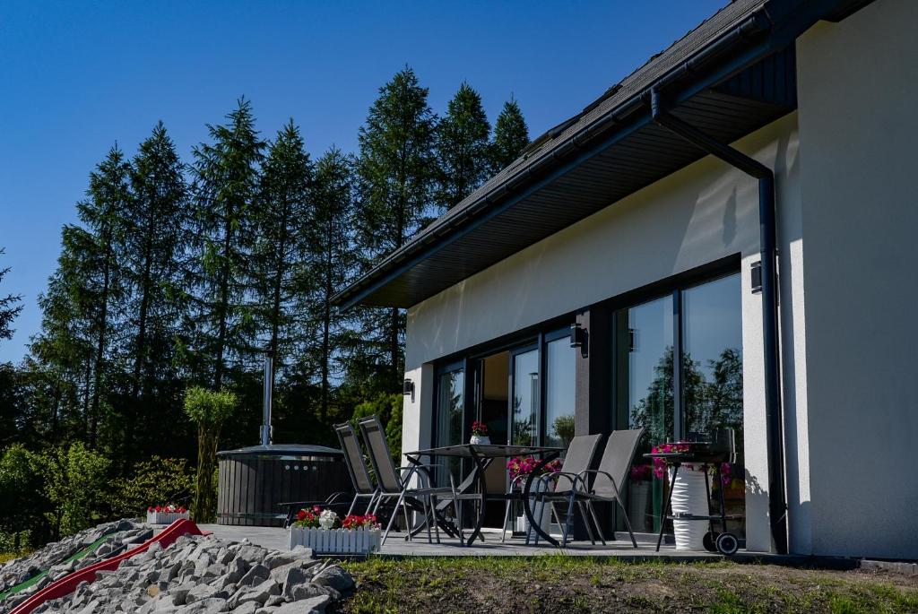 a house with a patio with chairs and a grill at Domek Veron in Wysowa-Zdrój