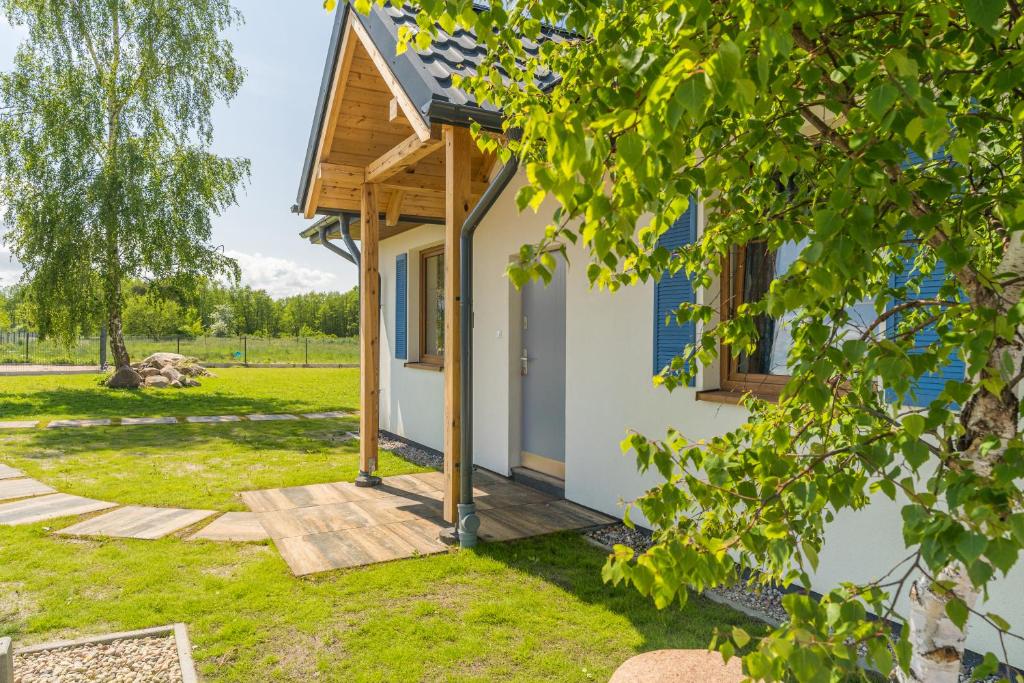uma pequena casa com um alpendre num quintal em Mila Morska Kopalino em Kopalino