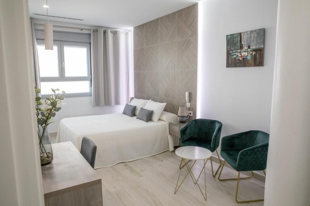 a bedroom with a bed and a table and chairs at Énfasis Hotel in El Cuervo