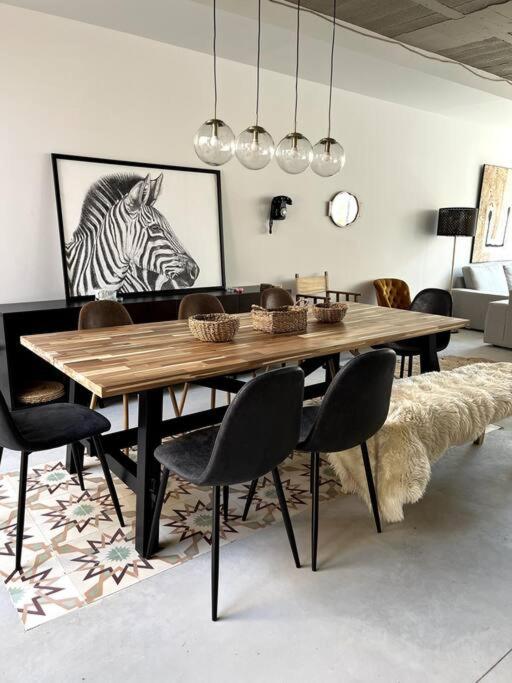 a dining room with a wooden table and chairs at Villa Vintage Dulcinea in Camuñas