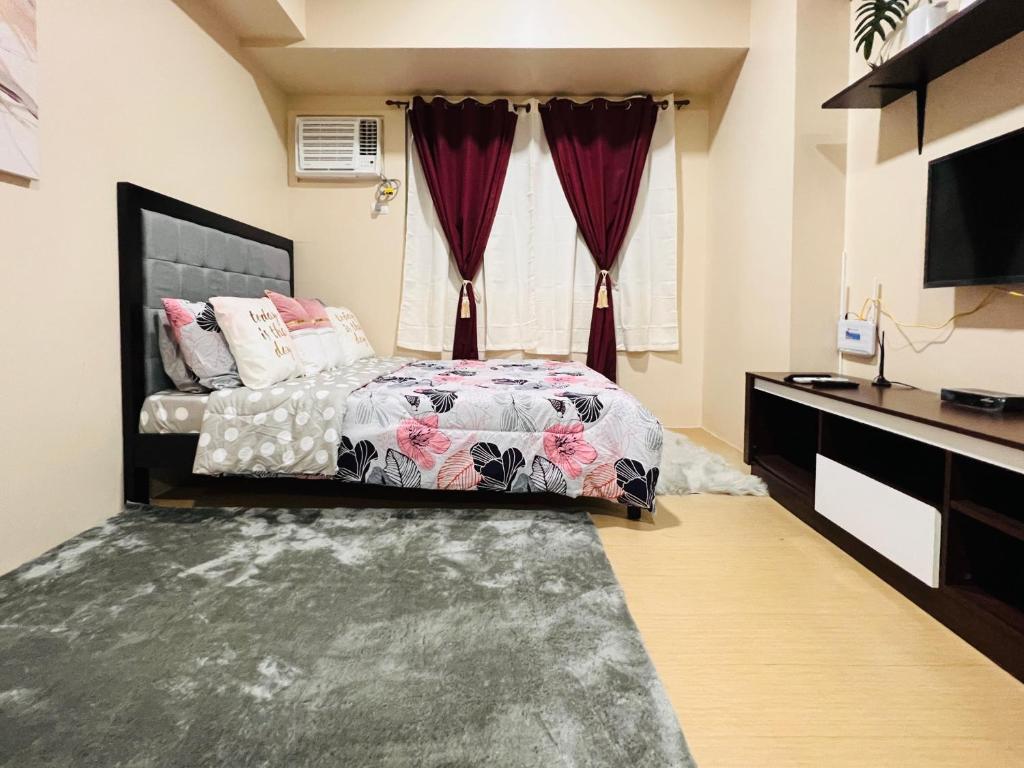 a bedroom with a bed with curtains and a television at * *K Irresistable value for 3 in Iloilo City