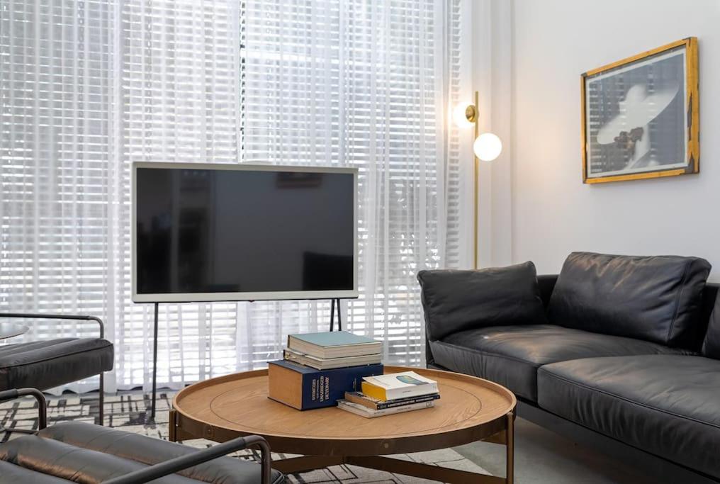 a living room with a couch and a flat screen tv at A Bauhaus Gem - Prime Location in Tel Aviv