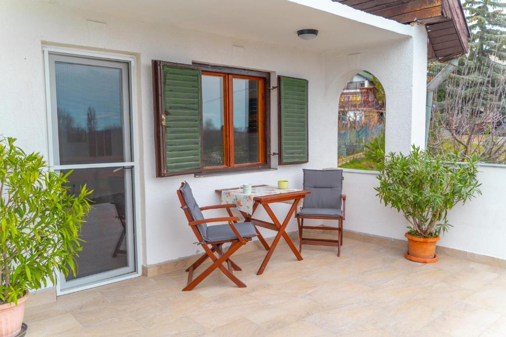 une terrasse avec une table et des chaises dans une maison dans l'établissement Csabagyöngye Apartman Badacsony, à Badacsony