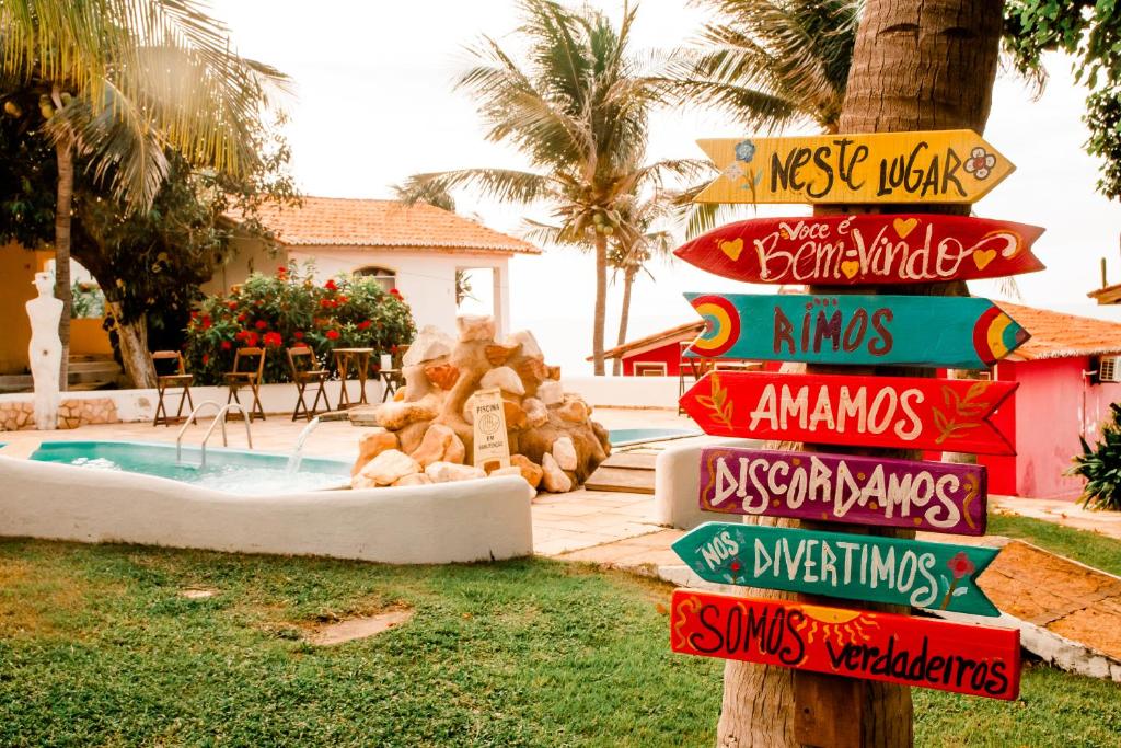 um sinal em frente a um resort com piscina em Lua Morena em Aracati