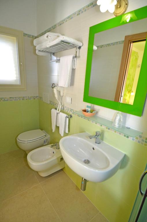 a bathroom with a sink and a toilet and a mirror at B&B Lu Cantoru in Marina di Pescoluse
